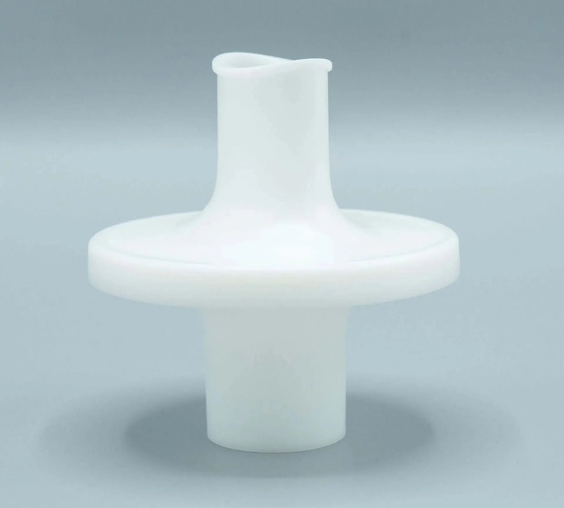 The bacterial/viral filter mouthpiece shown is elliptical in shape, white in color, and has a ridge around the opening, making it easier to maintain a seal.