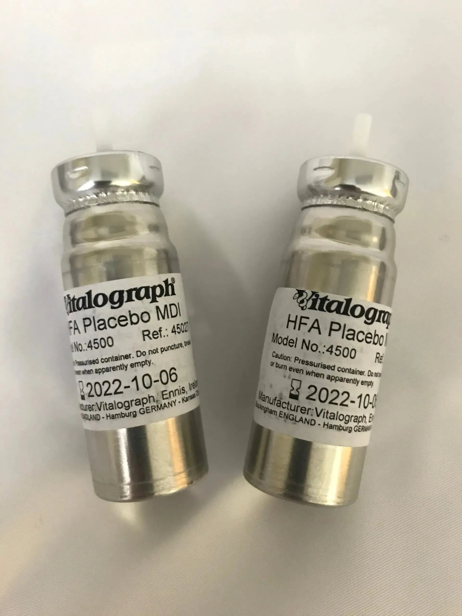 Two silver Placebo Aerosol Canisters.