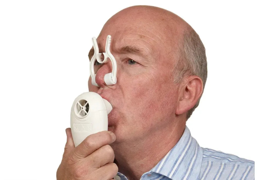 A man breathes using a set of white nose clips and a USB COPD Screener.